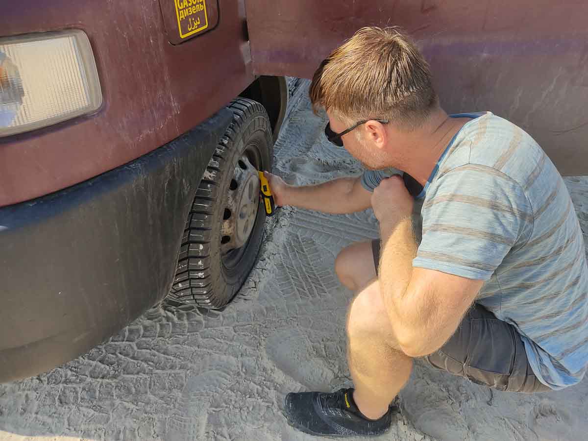 Fabian lässt den Reifendruck am Wohnmobil ab um besser im Sand fahren zu können