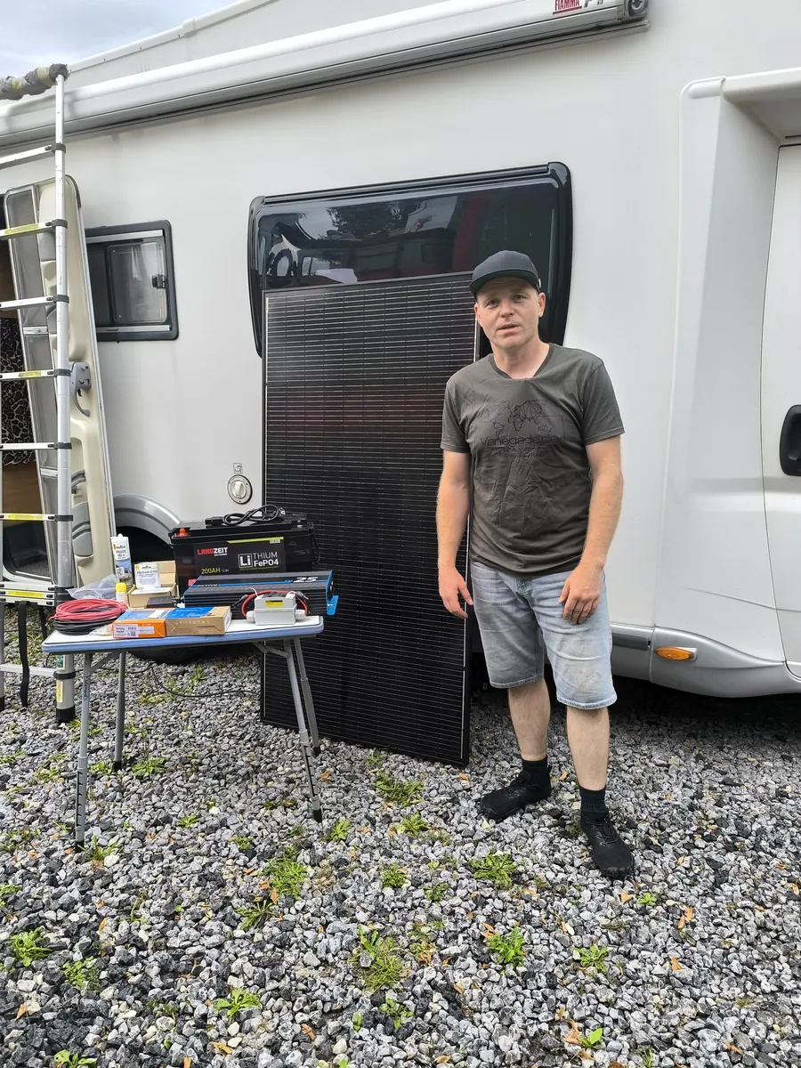 Fabian von Vanegade mit Solarmodul, LiFePO4-Batterie und Wechselrichter vor einem Wohnmobil